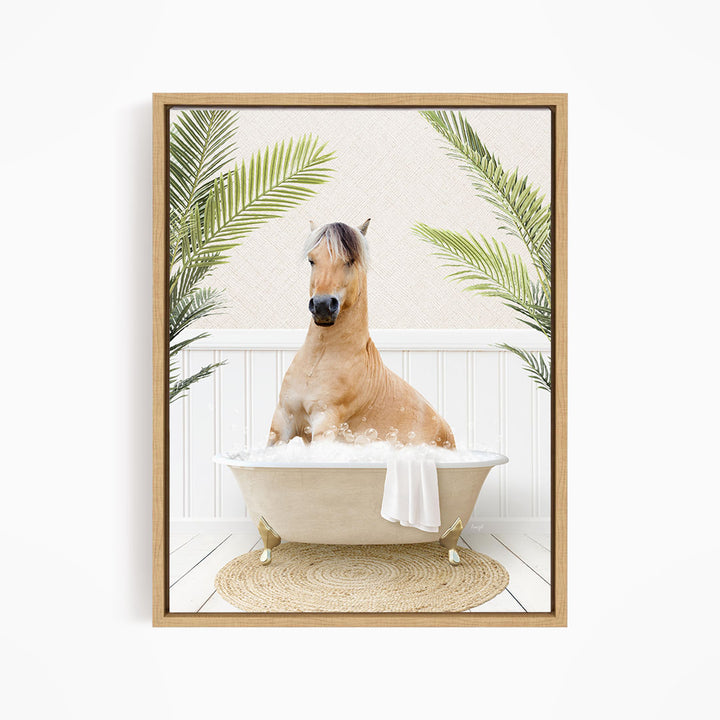 A light brown horse is sitting in a white bathtub filled with bubbles, surrounded by green palm leaves.