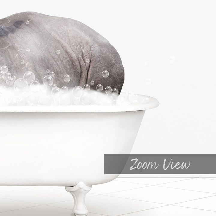 A large gray elephant is sitting in a white bathtub filled with bubbles, creating a whimsical and playful scene.