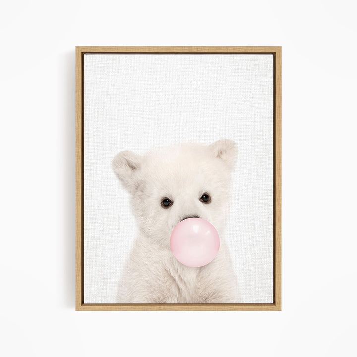 A cute white polar bear is blowing a bubble with a pink bubble gum bubble.