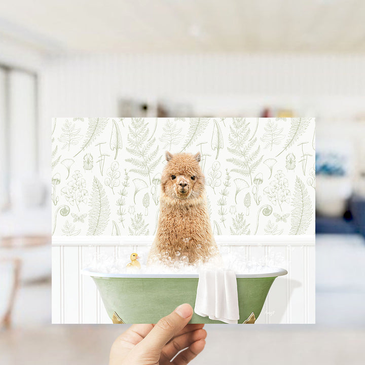 A hand holding a framed image of a small brown dog sitting in a green bathtub filled with bubbles, with a yellow rubber duck floating in the water.