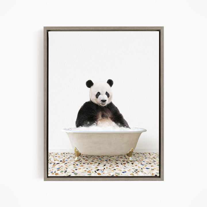 A panda bear sitting in a white bathtub filled with bubbles, looking directly at the camera.