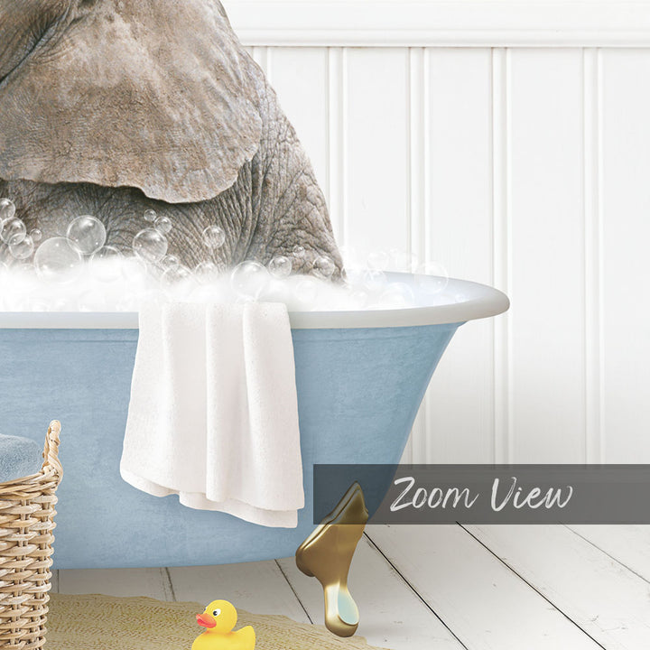 A large gray elephant is sitting in a blue bathtub filled with bubbles, surrounded by a yellow rubber duck and a white towel.