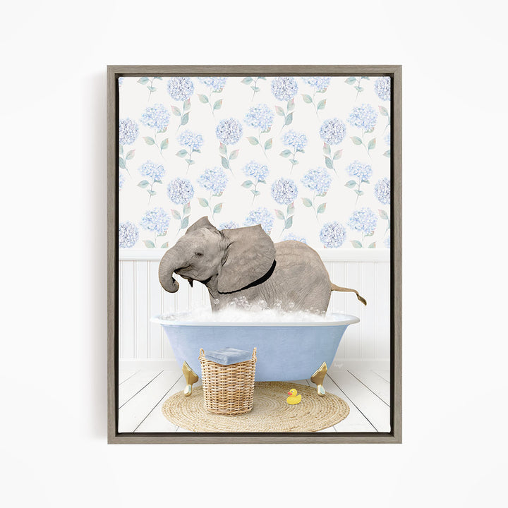 A gray elephant is sitting in a blue bathtub filled with water, surrounded by a wicker basket and yellow rubber ducks.