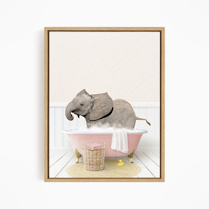 A gray elephant is sitting in a pink bathtub filled with water, surrounded by a yellow rubber duck and a basket.
