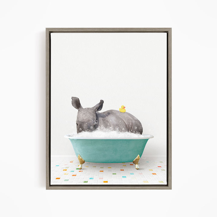 A rhinoceros is sitting in a blue bathtub filled with bubbles, with a yellow rubber duck floating on its back.