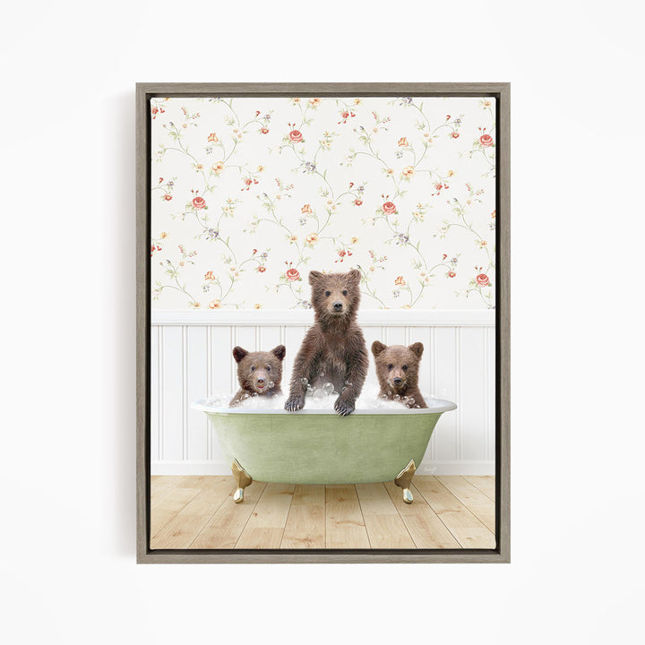 A framed image depicting three bears sitting in a green bathtub, with a floral wallpaper in the background.