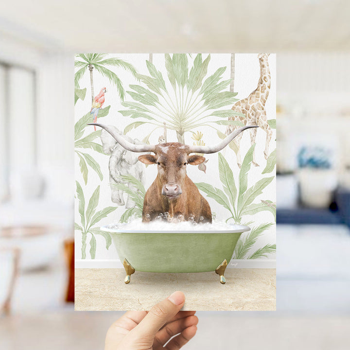A hand holds up a collage of an image featuring a brown cow with large horns sitting in a green bathtub surrounded by tropical plants and animals, including a parrot and a giraffe.