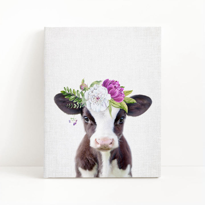 A cow with a floral crown on its head is the main subject of the image.