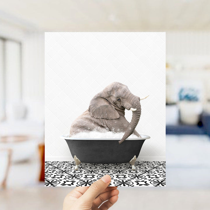 A gray elephant sitting in a black bathtub filled with water, surrounded by a black and white patterned floor.