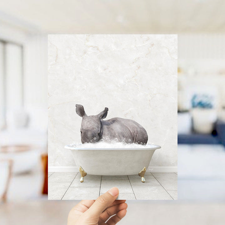 A rhinoceros is sitting in a bathtub filled with bubbles, creating a whimsical and playful scene.