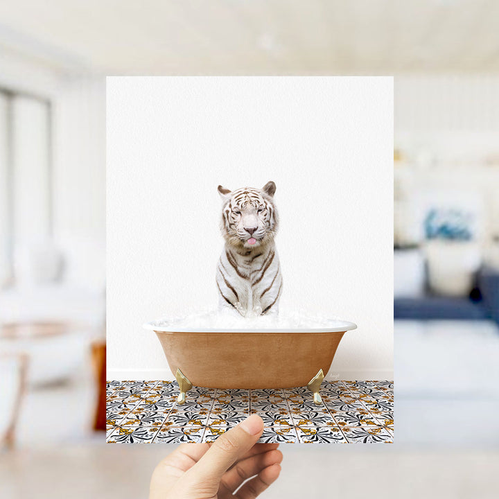 A white tiger is sitting in a bathtub filled with water, with a hand holding up the image to show it.