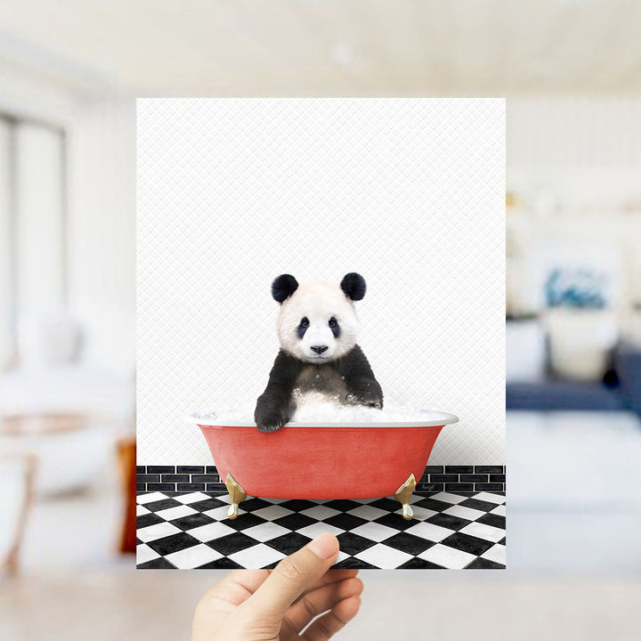 A panda bear sitting in a red bathtub on a black and white checkered floor.