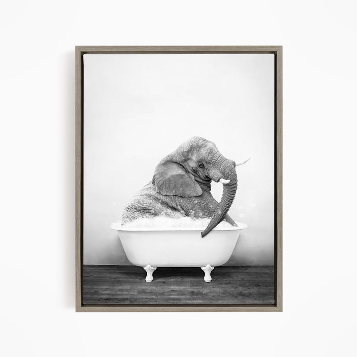 A black and white photograph of an elephant sitting in a bathtub filled with water.