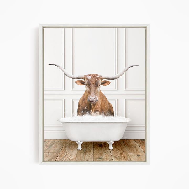 A brown cow with large horns is sitting in a white bathtub filled with water, creating a whimsical and humorous scene.