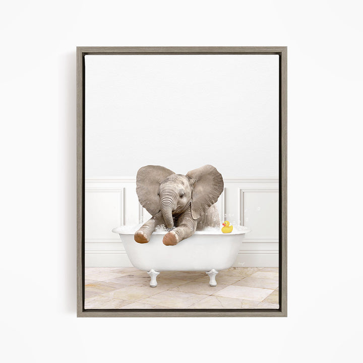 A baby elephant sitting in a white bathtub, with a rubber duck floating nearby.