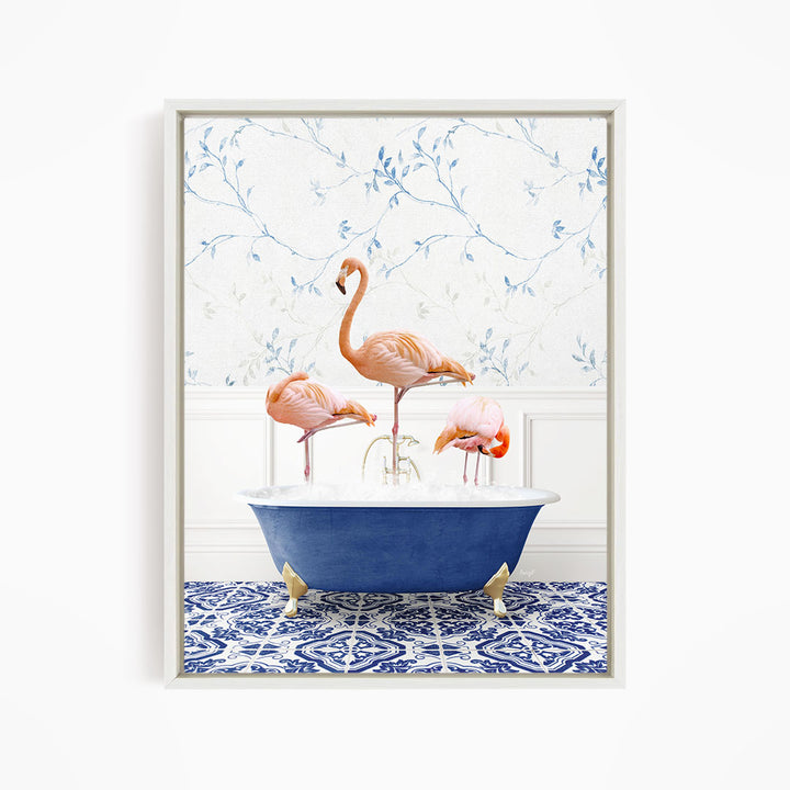 A framed image depicting three flamingos standing in a blue bathtub, with a patterned tile floor and a floral wallpaper in the background.