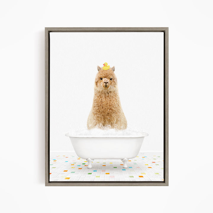 A fluffy brown alpaca sits in a white bathtub filled with bubbles, with a yellow rubber duck perched on its head.