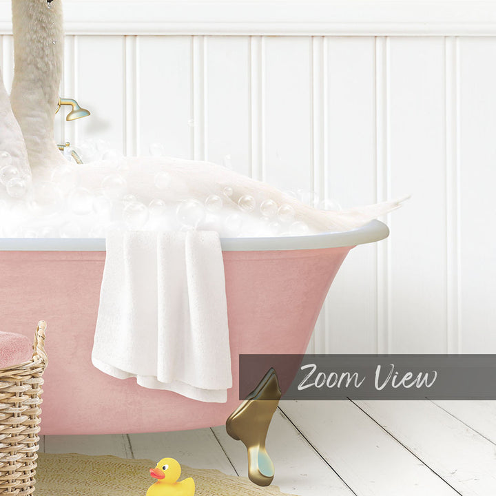 A pink claw-foot bathtub filled with bubbles, with a yellow rubber duck and a white towel nearby.