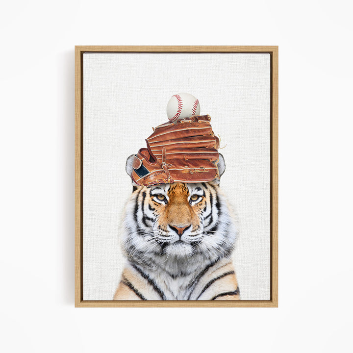 A tiger wearing a baseball cap and holding a baseball in its mouth.