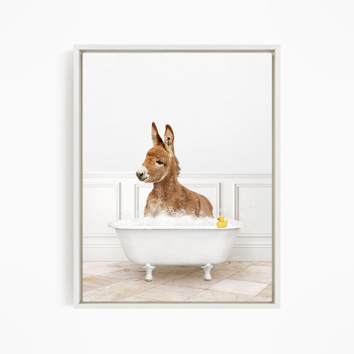 A donkey is sitting in a white bathtub filled with water, with a rubber duck floating in the water.