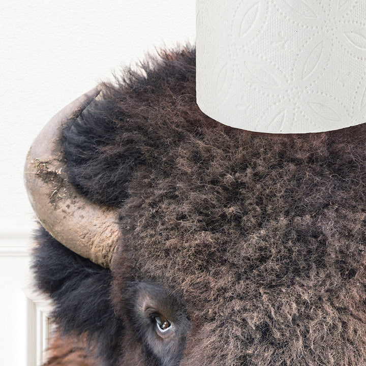 a close up of a bison head with a roll of toilet paper on it '