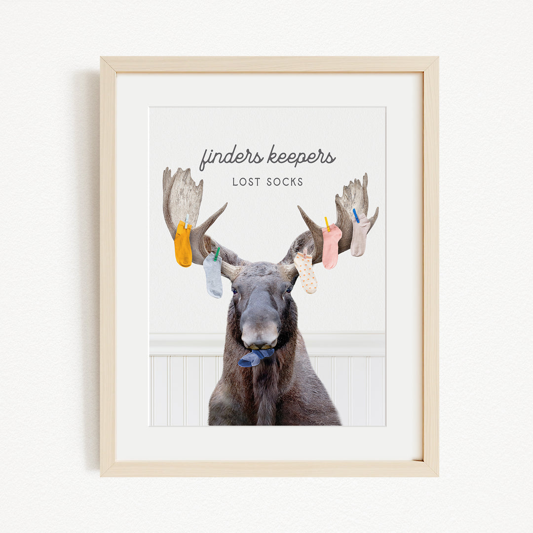 A framed image of a moose with a humorous caption that reads "finders keepers lost socks".