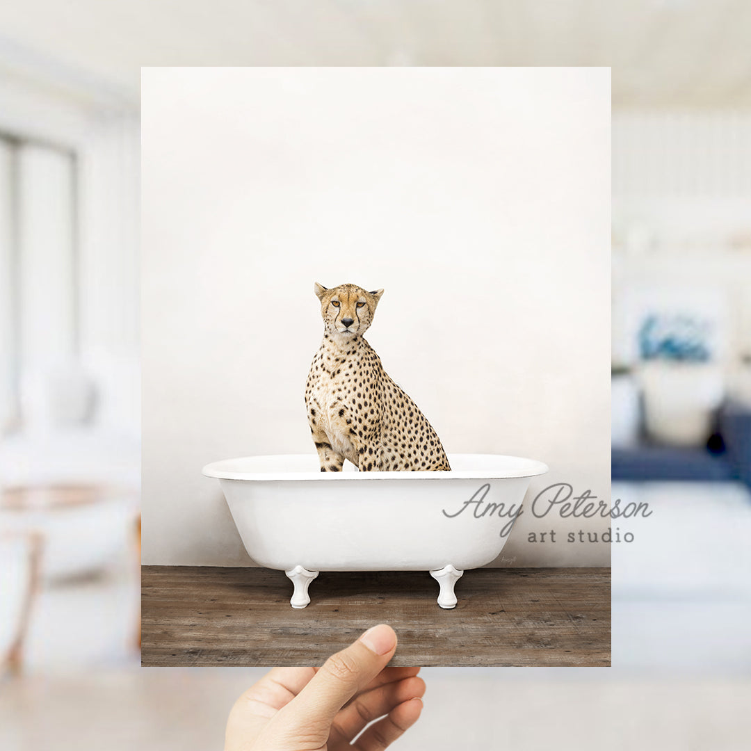 a hand holding up a photo of a cheetah sitting in a bathtub