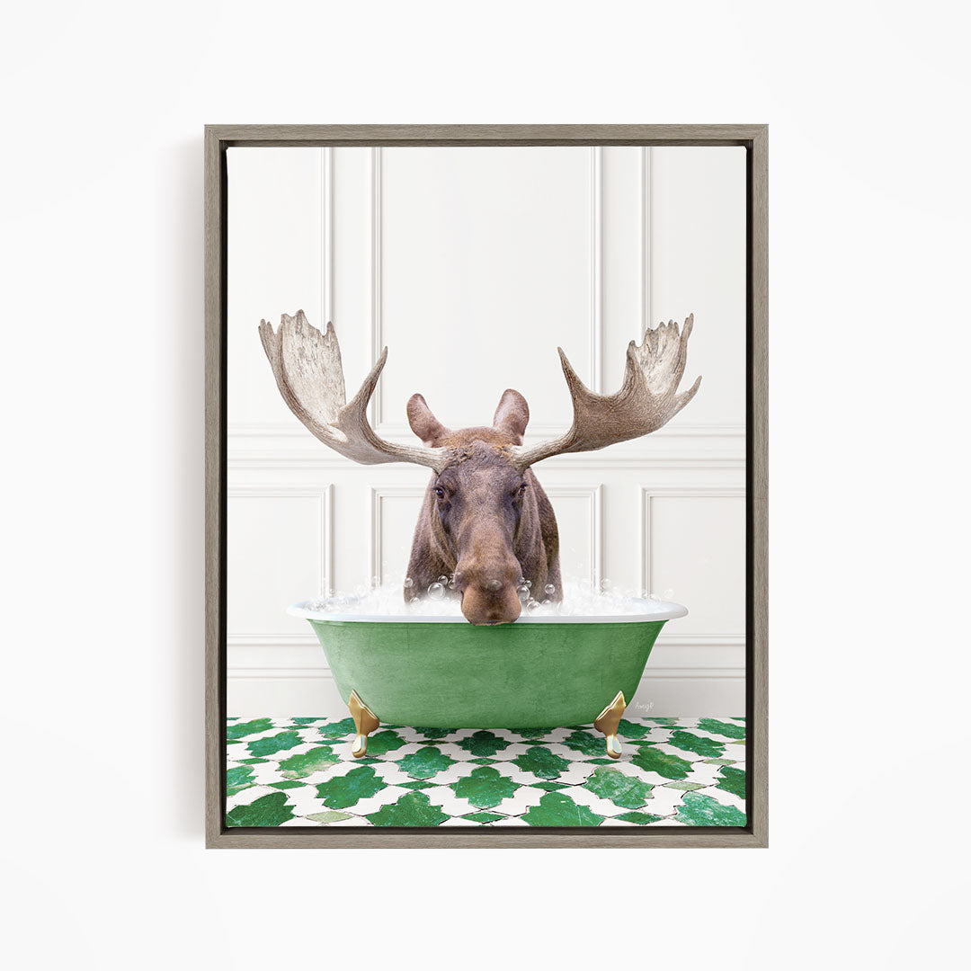 A moose with large antlers is sitting in a green bathtub filled with water, surrounded by a green and white patterned floor.