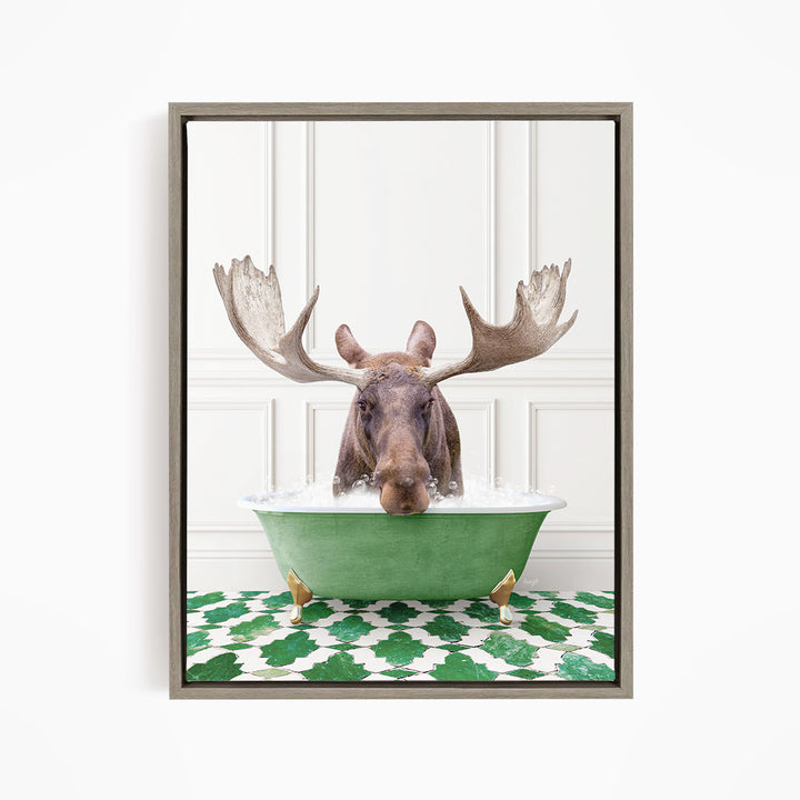 A moose with large antlers is sitting in a green bathtub filled with water, surrounded by a green and white patterned floor.