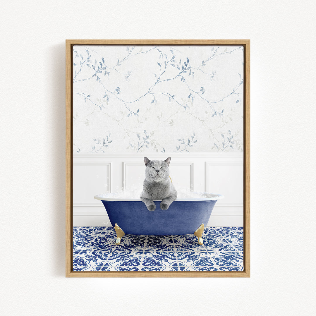 A gray cat sitting in a blue bathtub filled with bubbles, with a patterned tile floor and a floral wallpaper in the background.