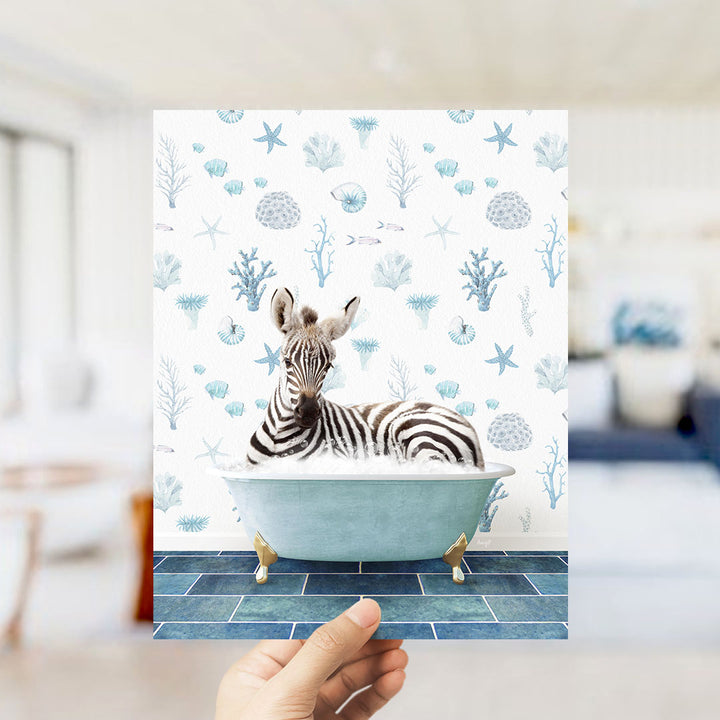 A zebra is sitting in a bathtub filled with water, surrounded by a pattern of blue and white seashells and starfish.