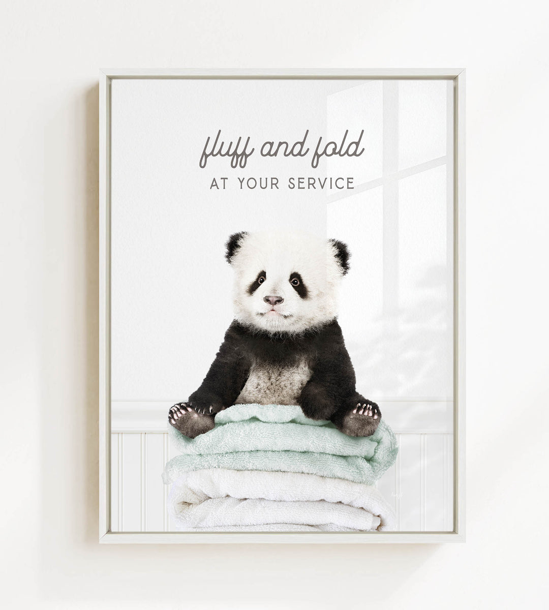 A panda bear sitting on a stack of towels, with the text "fluff and fold at your service" written above the image.