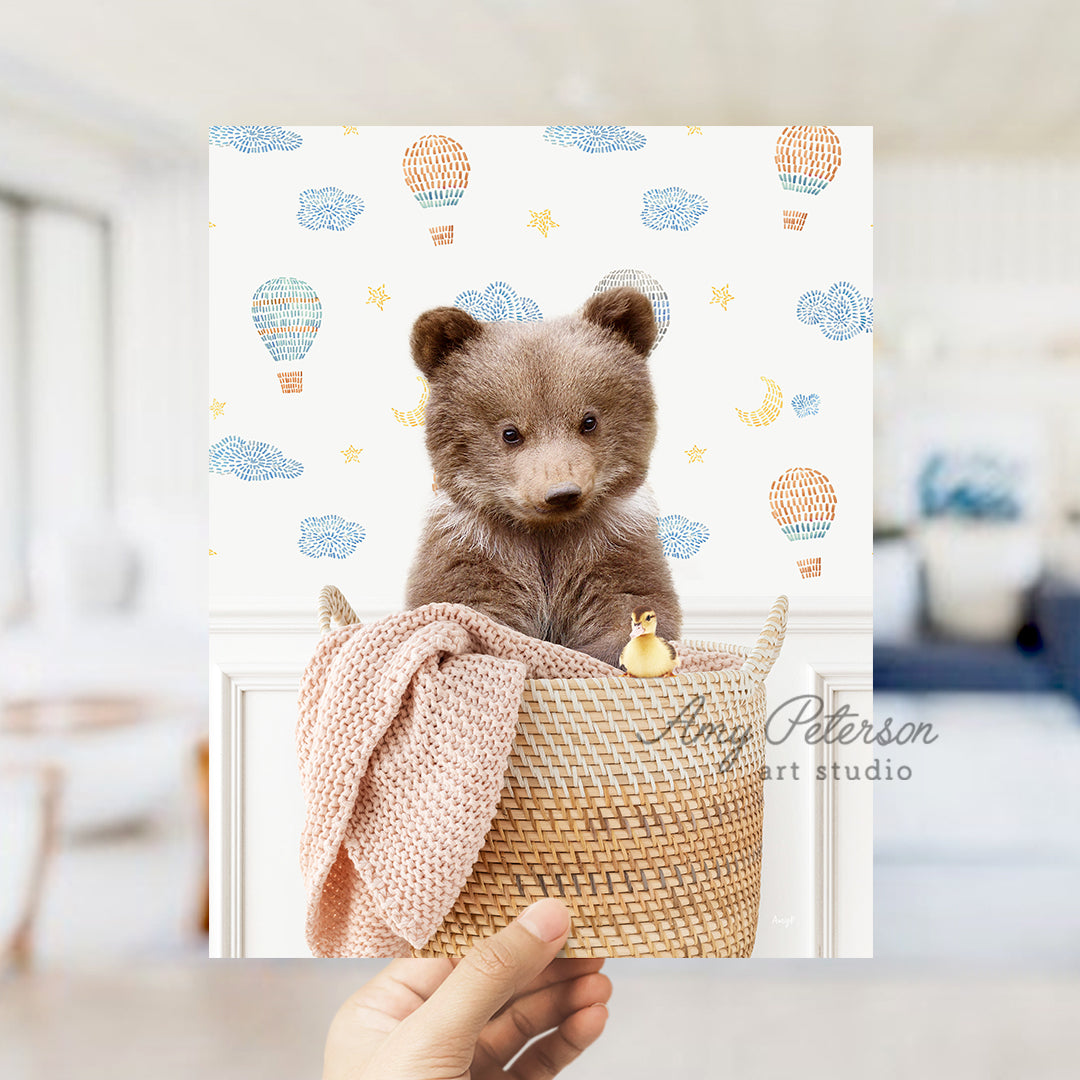 a person holding a picture of a teddy bear in a basket