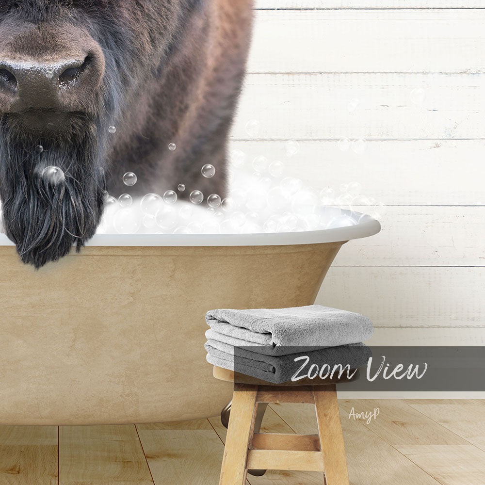 A close-up of a large animal, possibly a bison or a cow, standing in a bathtub filled with bubbles, with a towel and stool visible in the foreground.