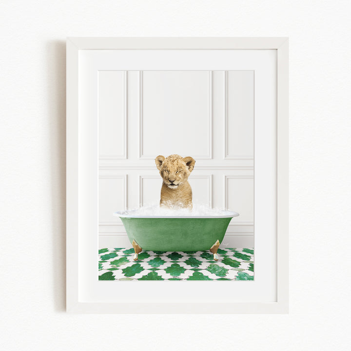 A young lion cub sitting in a green bathtub filled with water, surrounded by a green and white patterned rug.