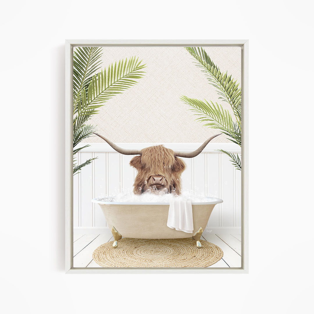 A brown cow with long horns is sitting in a white bathtub filled with water, surrounded by green palm leaves.