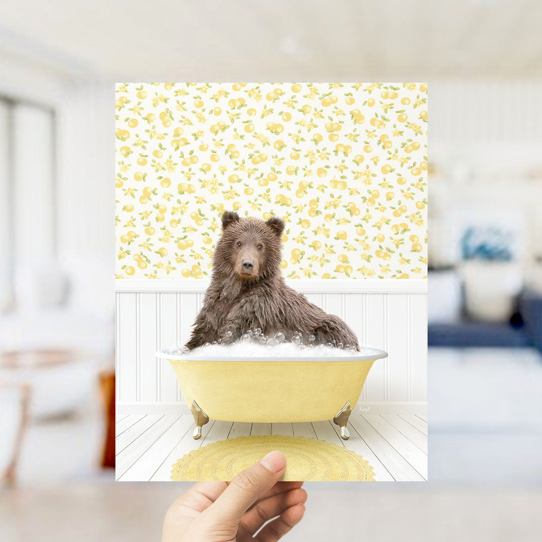 A brown bear sitting in a yellow bathtub filled with bubbles, surrounded by a yellow and white floral patterned wall.