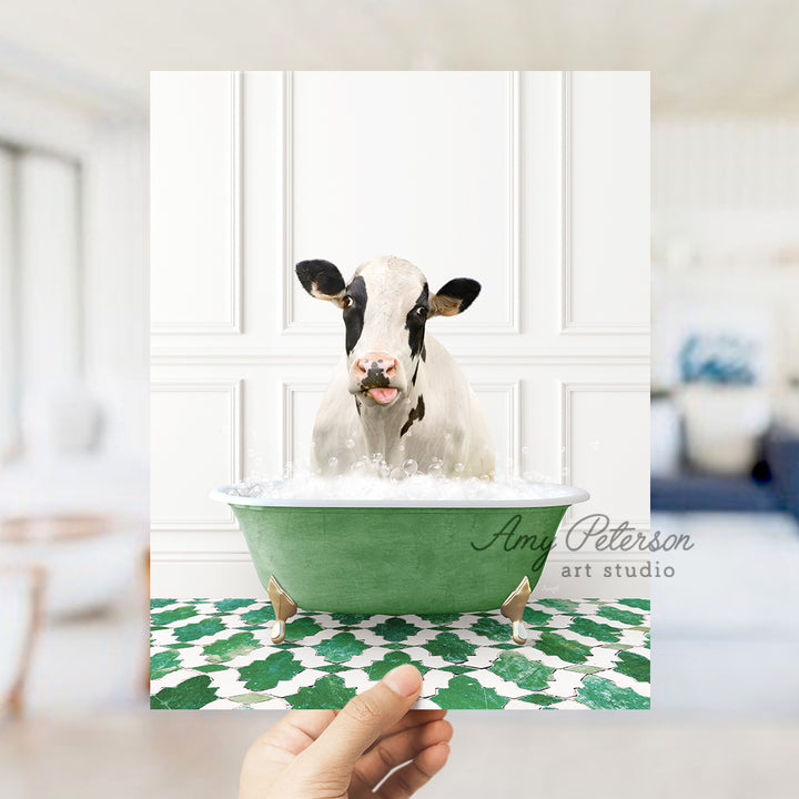 a hand holding a card with a picture of a cow in a bathtub