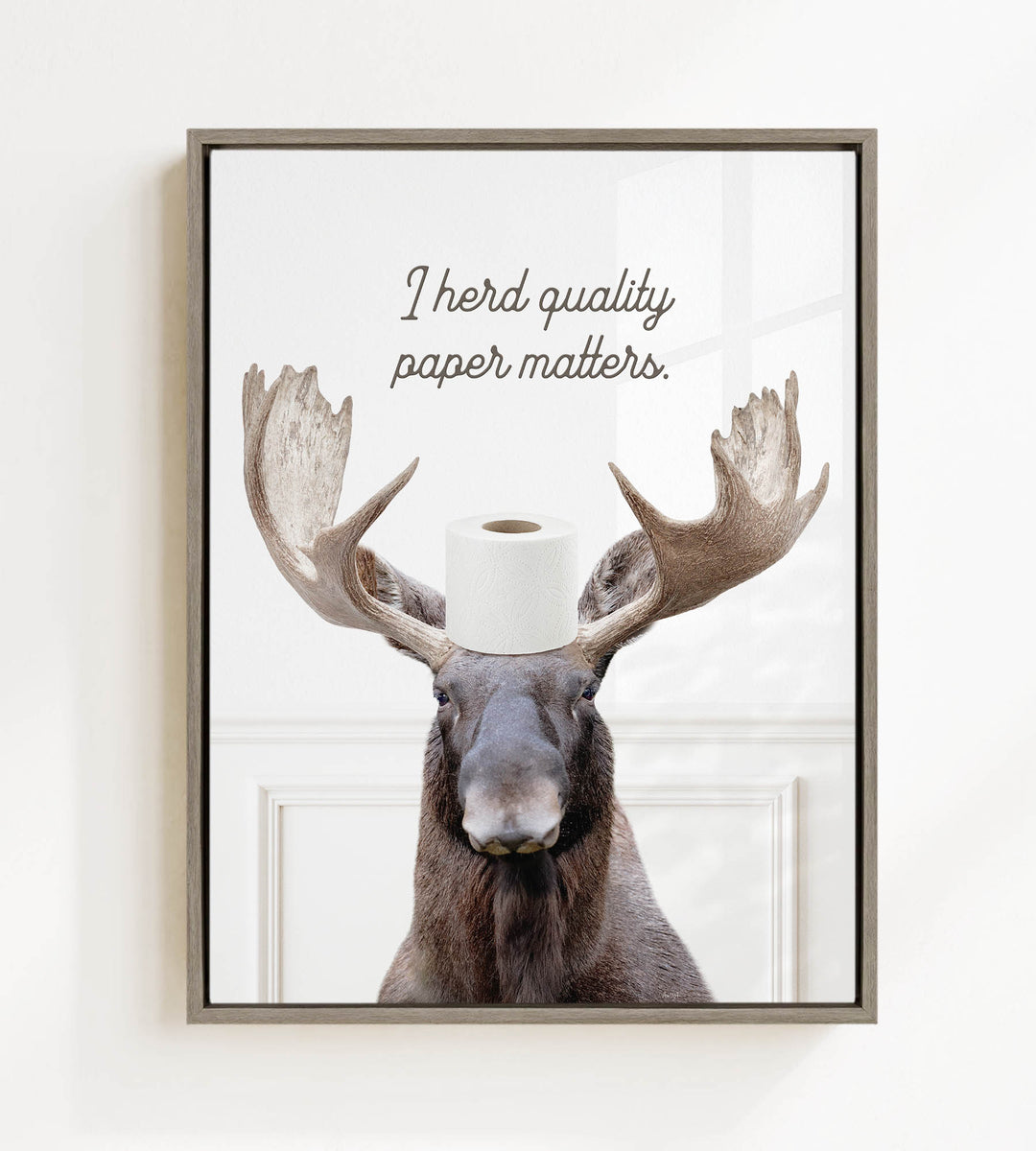 A moose with antlers wearing a roll of toilet paper on its head, with the text "I herd quality paper matters" above it.