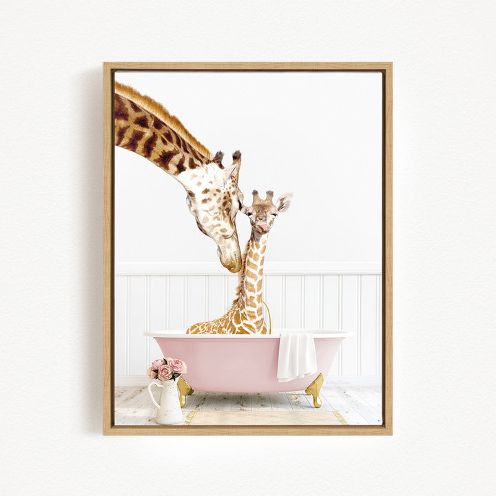 A mother giraffe and her baby giraffe are sitting together in a pink bathtub, with the mother gently licking her baby.