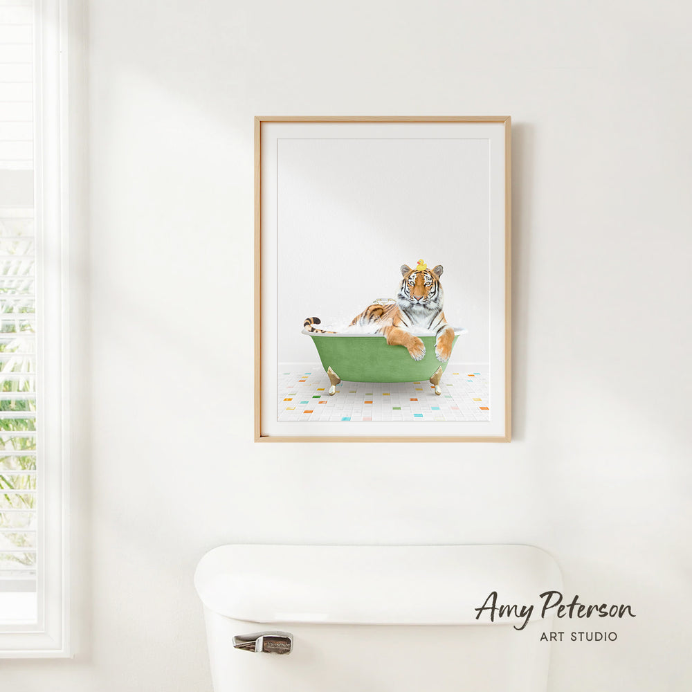 A framed print of a tiger sitting in a green bathtub is hanging on a white wall.