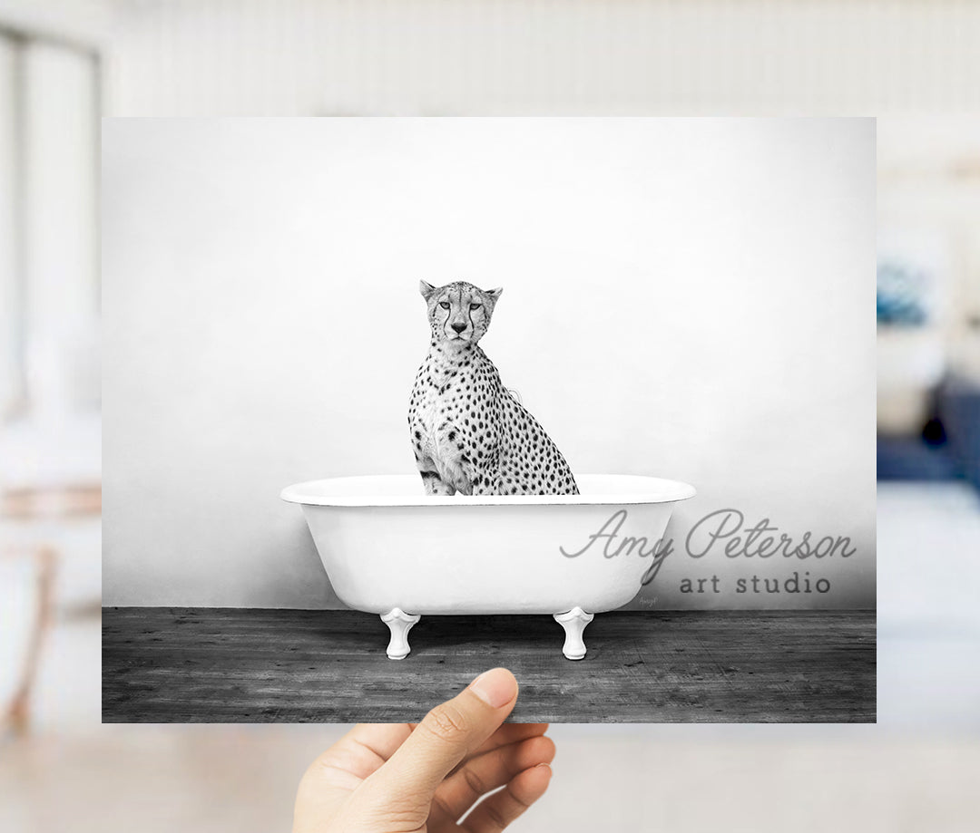 a black and white photo of a cheetah sitting in a bathtub