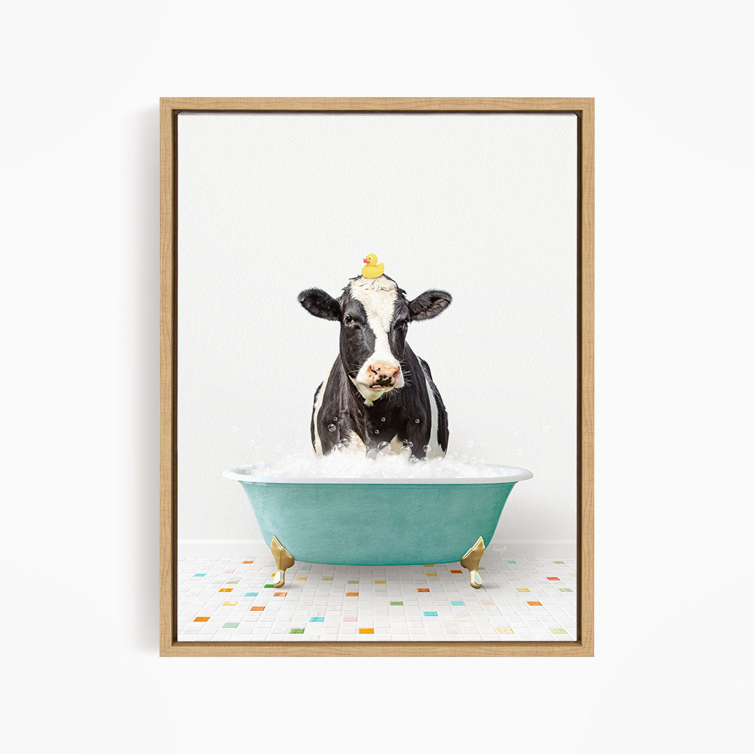 A black and white cow is sitting in a blue bathtub filled with water, with a yellow rubber duck perched on its head.