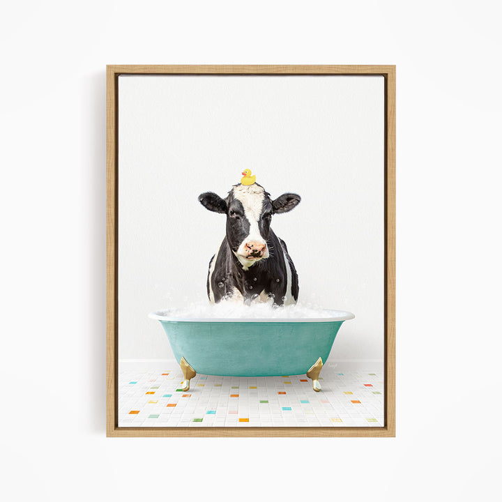 A black and white cow is sitting in a blue bathtub filled with water, with a yellow rubber duck perched on its head.