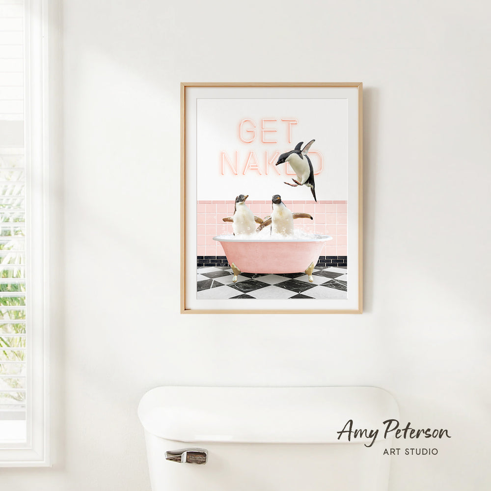 A framed print of two penguins sitting in a pink bathtub, with the text "GET NAKED" displayed above them.