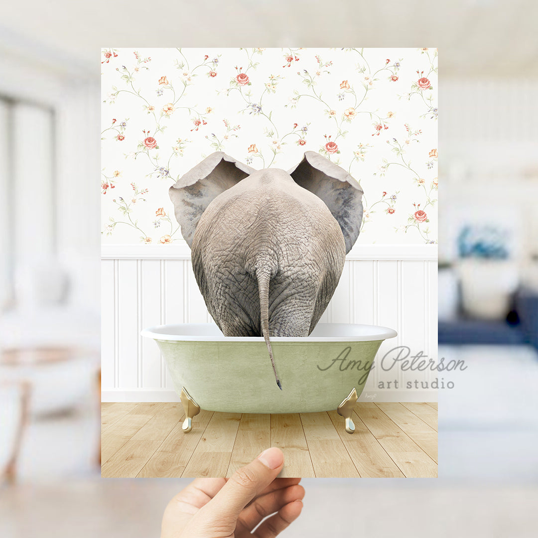 a person holding up a picture of an elephant in a bathtub