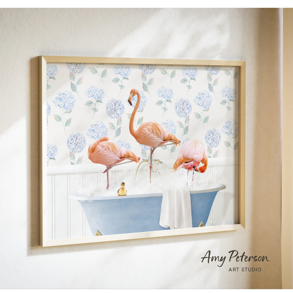 A framed print of a pink flamingo standing in a blue bathtub filled with bubbles, surrounded by a floral pattern.