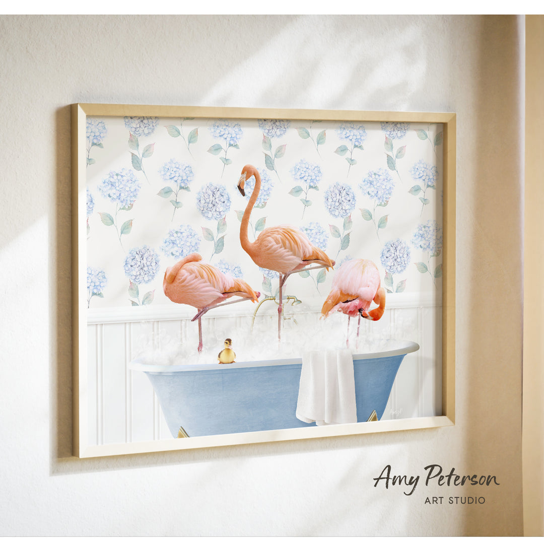 A framed print of a pink flamingo standing in a blue bathtub filled with bubbles, surrounded by a floral pattern.