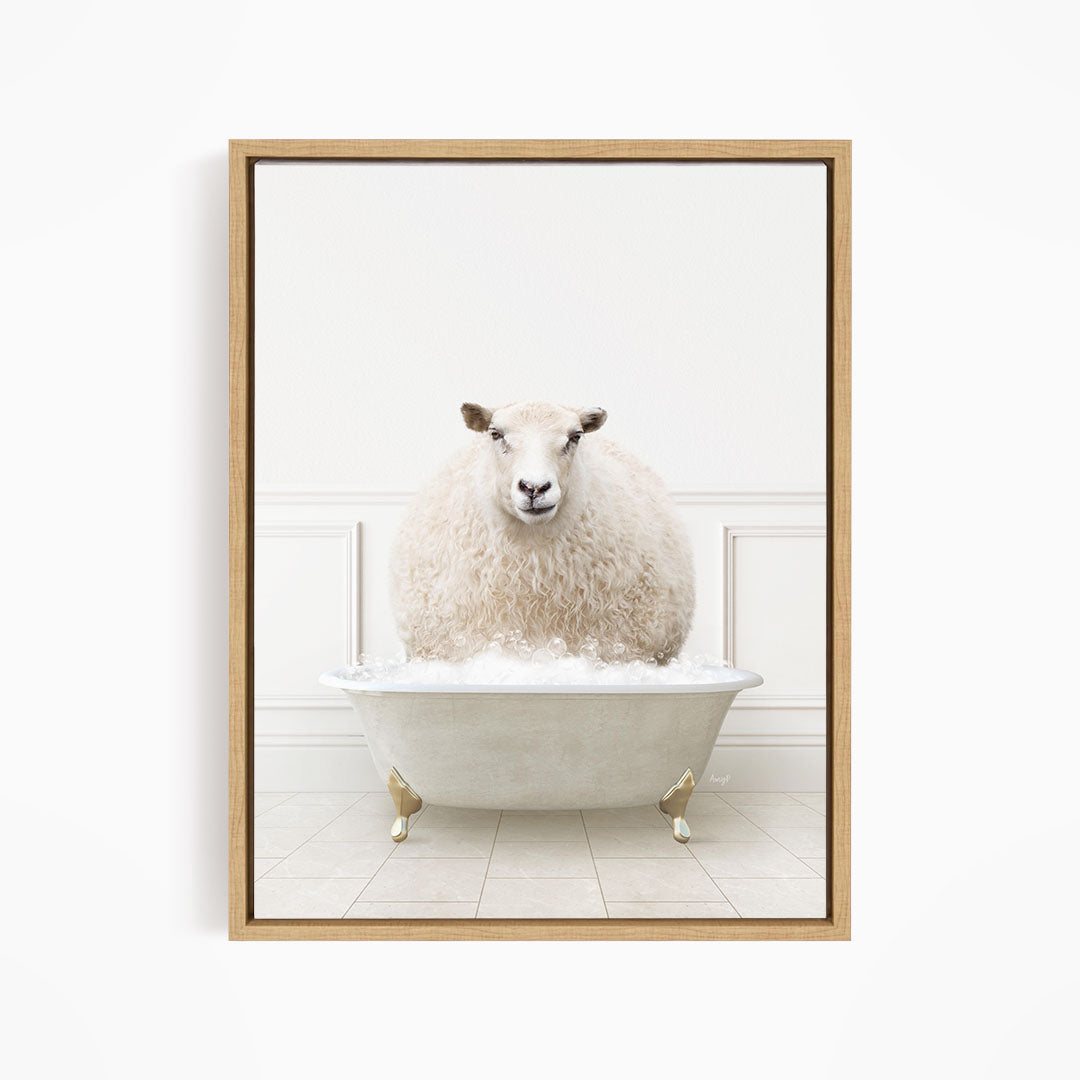 A fluffy white sheep sits in a white bathtub filled with bubbles, looking directly at the camera.
