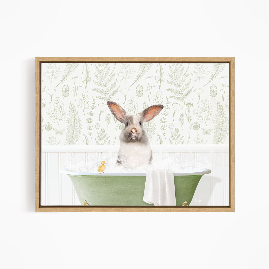 A small rabbit sitting in a green bathtub filled with water, surrounded by a white towel and a yellow rubber duck.